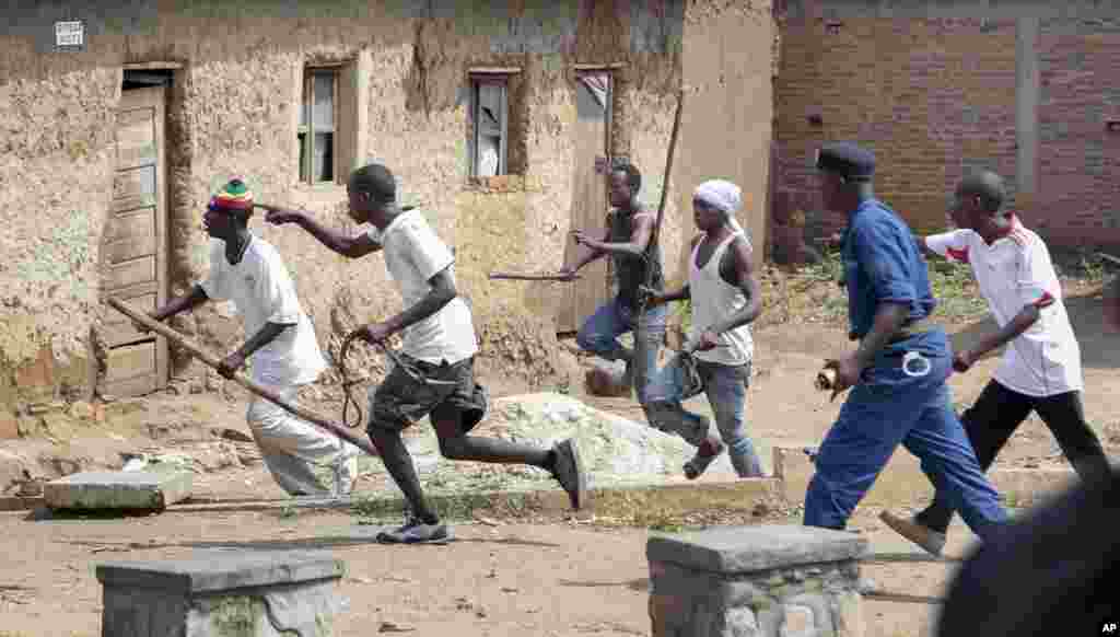 Members of the Imbonerakure pro-government youth militia chase after opposition protesters, unhindered by police, in the Kinama district of the capital Bujumbura, May 25, 2015.