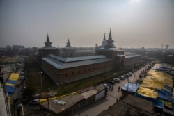 Warga Kashmir berjalan melewati pasar di luar Masjid Jamia, atau masjid agung di Srinagar, Kashmir yang dikuasai India, 12 November 2021. (Foto: AP/Mukhtar Khan)