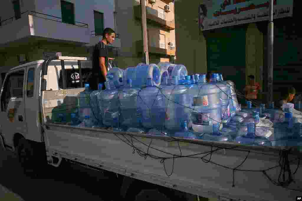 A man sells water from the back of a truck in Tripoli, Libya. Water has been cut off throughout the city, August 26, 2011. (VOA Photo - J. Weeks)