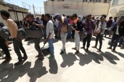 FILE - Ethiopian migrants wait to be registered at a International Organization for Migration temporary shelter after being returned from Yemen to the capital Addis Ababa, Ethiopia, Jan. 31, 2019.