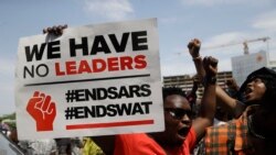 Des gens brandissent des banderoles alors qu'ils manifestent dans la rue pour protester contre les brutalités policières à Lagos, au Nigeria, le jeudi 15 octobre 2020. (AP Photo/Sunday Alamba)