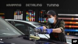 Detailer mobil asal Iran Maryam Roohani memoles mobil di bengkel detailing di Teheran, Iran, 18 April 2021. (Foto: AP)