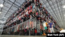 Thousands of clotthes are stored on a three-level system at the ThredUp sorting center in Phoenix on March 12, 2019. (AP Photo/Matt York, File)