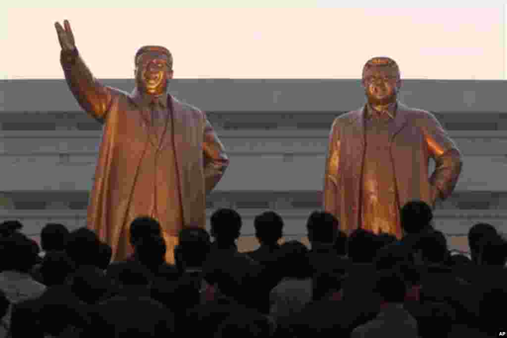 North Koreans pay tribute after the unveiling ceremony of statues of late leaders, Kim Il Sung, left, and Kim Jong Il in Pyongyang, North Korea, Friday, April 13, 2012. (AP Photo/Vincent Yu)