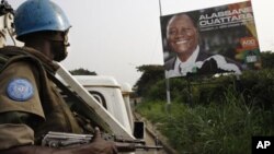 Sojojin kiyaye zaman lafiya na Majalisar Dinkin Duniya daga Nijar,suke sintiri suna wucewa kusa da hoton Alassane Ouattara.