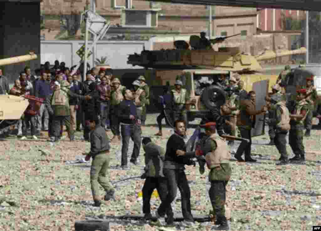 Pro-government supporters are restrained by soldiers just outside Cairo's main square, Egypt, Thursday, Feb. 3, 2011. Egypt's prime minister apologized for the attack by regime supporters on anti-government protesters in central Cairo, vowing to investiga