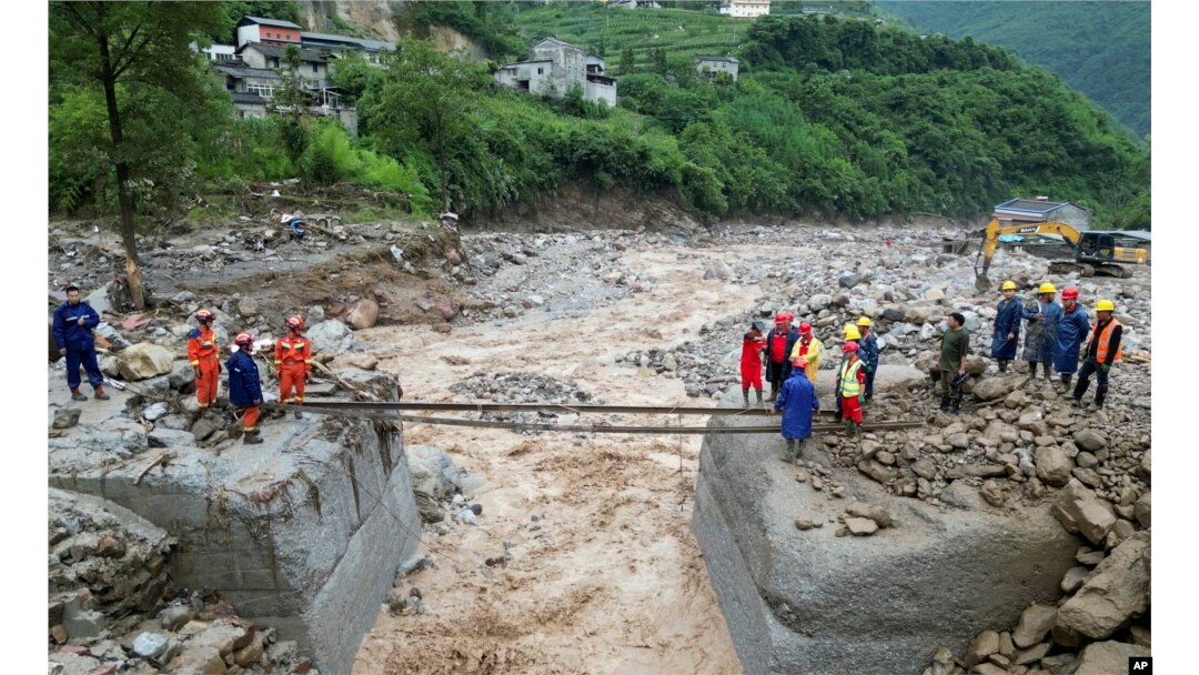 Petugas penyelamat membuat penyeberangan setelah ambruk karena hujan pada 20 Juli 2024. (Xinhua via AP)