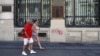 Tourists walk past Spain's former Banco Espanol de Credito in Madrid, August 28, 2012. 