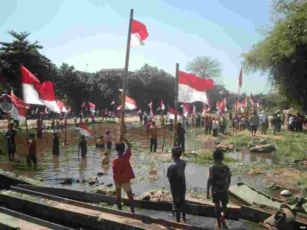 Warga bantaran Sungai di Kali Anyar, Cinderejo, Solo, menggelar upacara bendera di sungai untuk merayakan Ulang Tahun ke-73 kemerdekaan Republik Indonesia, Jumat, 17 Agustus 2018. (Foto: Yudha Satriawan/VOA)