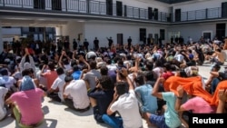 FILE - Victims of scam centers who were tricked or trafficked into working in Myanmar, stuck in limbo at a compound inside the KK Park, a fraud factory, and a human trafficking hub on the Thailand-Myanmar border in Myawaddy, Myanmar, Feb. 26, 2025.