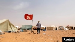 Un protestataire marche près de sa tente lors d'un sit-in à El-Kamour, près de la ville de Tatouine, en Tunisie, le 11 mai 2017.