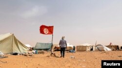 Un protestant tunisien marche près de sa tente lors d'un sit-in à El-Kamour, près de la ville de Tatouine, en Tunisie, le 11 mai 2017.