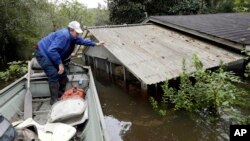 Florence, S.C., resident Jackie Lee surveys the flooding to his property along the Lynches River near Effingham, S.C., where houses and cars are swamped following record rainfall in the state, Oct. 6, 2015.