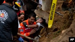 Seorang petugas pemadam kebakaran diselamatkan setelah terjebak ketika bekerja di lokasi terjadinya longsor di Cambray, di pinggiran kota Santa Catarina Pinula, sekitar 10 mil sebelah timur Guatemala City, 3 Oktober 2015. 