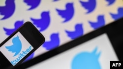 FILE - Logos of U.S.-based social network Twitter are displayed on the screens of smartphones in an illustration photo.