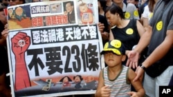 香港民眾舉著反對“惡法”的標語準備參加反對23條立法的大遊行。(2003年7月1日)