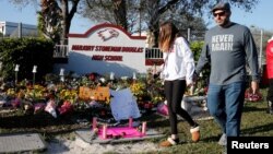 Pengunjung melewati memorial yang menandai satu tahun peringatan peristiwa penembakan massal di SMA Marjory Stoneman di kota Parkland, Florida.