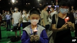 Participants holds candles during a vigil for the victims of the 1989 Tiananmen Square Massacre at Victoria Park in Causeway Bay, Hong Kong, June 4, 2020, despite applications for it being officially denied. 