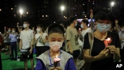 Participants holds candles during a vigil for the victims of the 1989 Tiananmen Square Massacre at Victoria Park in Causeway Bay, Hong Kong, June 4, 2020, despite applications for it being officially denied. 