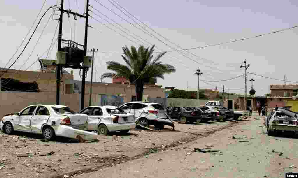 Cars are damaged at the site of a car bomb attack in the town of Jalawla, Iraq, June 8, 2014. 