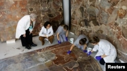 Pilar Roig Picazo, 75, and her daughter Pilar Bosch Roig, 42, watch as restorers work on a mural painting removed from the Santos Juanes church in Valencia, Spain, September 17, 2024. (REUTERS/Eva Manez)