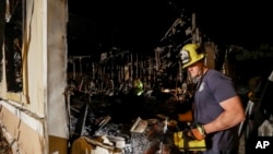 A fireman looks over a home Saturday, July 6, 2019 that burned after a earthquake in Ridgecrest, Calif. The Friday evening quake with a magnitude of about 7.1 jolted much of California, cracking buildings, setting fires, breaking roads and causing…