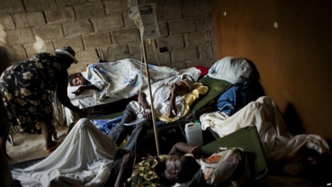 People suffering cholera symptoms rest on stretchers as they crowd the entrance of a public hospital in Limbe village near Cap-Haïtien, Haiti, 22 Nov 2010