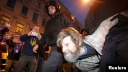 Des policiers emmènent un manifestant pro-leader de l’opposition Alexei Navalny lors d’un rassemblement à Saint-Pétersbourg, Russie, 7 octobre 2017.