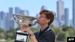 Petenis Italia Jannis Sinner berpose dengan trofi Norman Brookes Challenge Cup setelah mengalahkan Alexander Zverev dari Jerman pada laga final tunggal putra turnamen tenis Australia Terbuka di Melbourne pada 27 Januari 2025. (Foto oleh William West/ AFP
