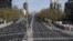 A woman crosses the usually busy La Castellana avenue in Madrid, Spain, the latest European nations to severely curtail people's movements to fight the coronavirus pandemic.