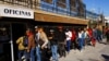 Migrantes venezolanos hacen fila para obtener asesoramiento legal gratuito para acceder a la aplicación CBP ONE de Aduanas y Protección Fronteriza (CBP) en un centro de Ciudad Juárez, México, 27 de enero de 2023. (REUTERS)