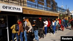 Para migran yang mencari suaka ke AS antre untuk mengakses permohonan online Bea Cukai dan Perlindungan Perbatasan AS (CBP) di pusat kota Ciudad Juarez, Meksiko (foto: dok). 