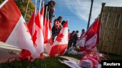 지난 22일 캐나다 오타와 총기 사건으로 사망한 경비병 네이튼 시릴로의 집에서 24일 시릴로의 아들이 다니는 학교 교직원들이 유가족에게 애도를 표하고 있다.