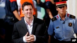 FILE - Argentine soccer star Lionel Messi (L) arrives at a court to answer questions in a tax fraud case in Gava, near Barcelona, Spain, Sept. 27, 2013.