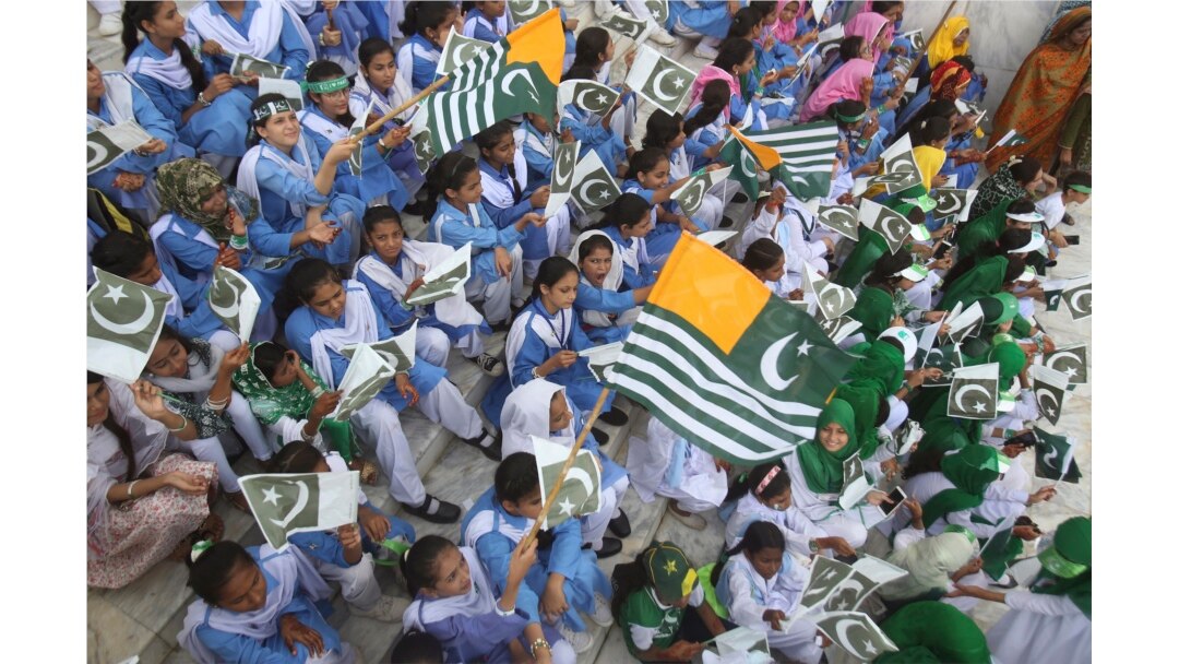 Pakistani students wave Pakistani and Kashmiri flags at the mausoleum of Muhammad Ali Jinnah, founder of Pakistan, to celebrate the Independence Day in Karachi, Pakistan, Aug. 14, 2019.