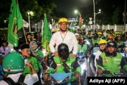 Cagub Jakarta Ridwan Kamil (kiri) dan cawagub Suswono (kedua dari kanan) tiba di kantor KPUD Jakarta untuk mengikuti pengundian nomor pasangan dalam pilkada Jakarta, 23 September 2024. (Foto: Aditya Aji/AFP)