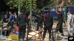 Egyptian riot police smash furniture and other items as they clear Tahrir Square in Cairo, September 15, 2012. 