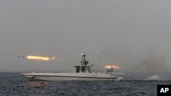 An Iranian navy boat fires a missile in a drill in the sea of Oman, December 30, 2011.