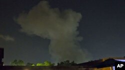 A plume of smoke rises following an late-night airstrike in Tripoli, Libya, May 24, 2011