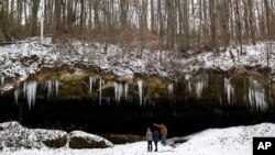 Tom Craig, a 20-year resident and member of the New Straitsville History Group, right, takes two AmeriCorps members on a tour of the Robertson Cave, a tourist attraction that was once home to secret meetings for early labor union organizers in the late 18