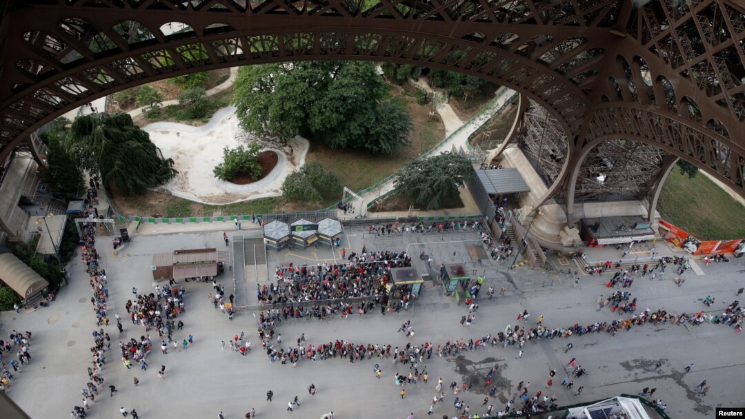 FILE - Visitors queue to visit the Eiffel Tower in Paris, France, June 2, 2018. A rule change earlier this month has meant even longer lines at the popular tourist spot.