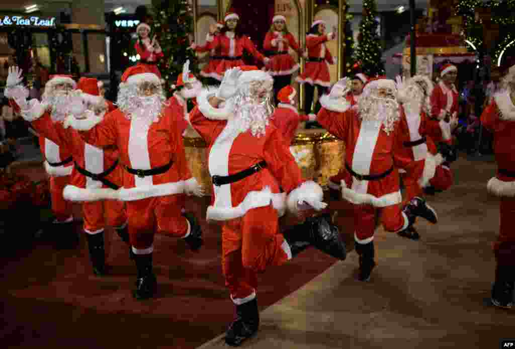 Performers clad in Santa Claus outfits dance at a shopping mall in Kuala Lumpur, Malaysia.