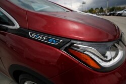 FILE - The electric vehicle logo shines off the fender of a 2019 Bolt at a Chevrolet dealership in Englewood, Colo., May 19, 2019.