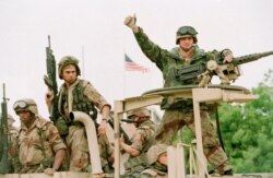 FILE - A U.S. Marine gives the thumbs up as a truckload of troops arrive at the U.S. Embassy in Mogadishu, Somalia, Dec. 10, 1992.