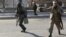 Afghan police officers run to Kabul traffic police headquarters as it is attacked by insurgents in Kabul January 21, 2013.