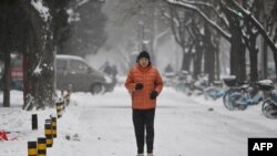 ภาพผู้ชายกำลังวิ่งกลางหิมะในกรุงปักกิ่ง เมื่อ 14 ธันวาค 2023 (ที่มา: แฟ้มภาพ/AFP)