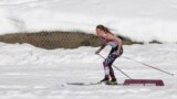 United States' Sophie Caldwell skis with a sleeveless top as temperatures went well over the freezing point during the women's 10K classical-style cross-country race at the 2014 Winter Olympics, Feb. 13, 2014.