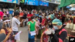 People stand in lines to get COVID-19 tests in Samut Sakhon, South of Bangkok, Thailand, Sunday, Dec. 20, 2020. Thailand reported more than 500 new coronavirus cases on Saturday. (AP Photo/Jerry Harmer)