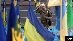 Un oficial de la 10.ª Brigada de Asalto de Montaña y veterano de la guerra ruso-ucraniana presenta sus respetos en un monumento improvisado a los soldados ucranianos caídos en en Kiev, el 28 de mayo de 2024, en medio de la invasión rusa de Ucrania. [Foto: Archivo/AFP]
