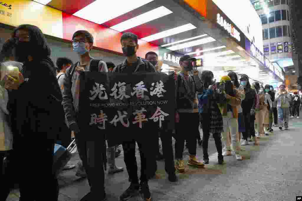 Un manifestante sostiene una pancarta que dice: "Liberen a Hong Kong. Una revolución de nuestros tiempos", mientras la gente forma una cadena humana en la víspera de Año Nuevo en Hong Kong. 